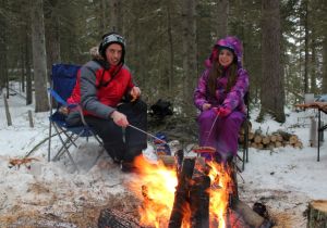 Staying warm and cooking smokies over a blazing fire.