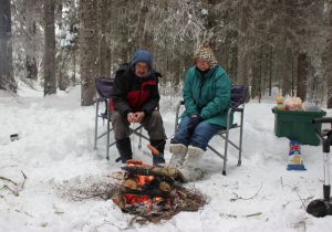 Taking a break from the action cooking smokies over a hot fire.